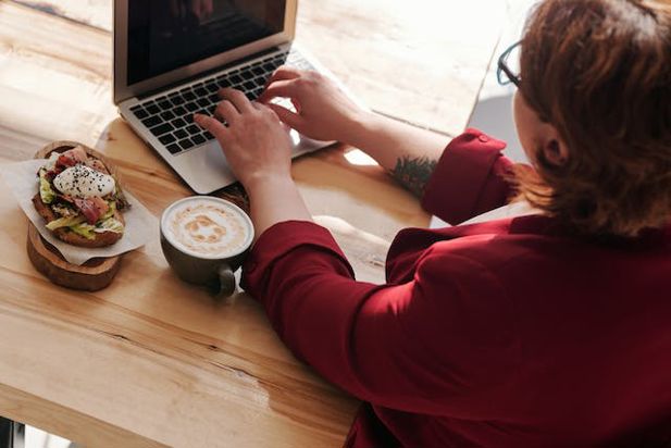 Woman typing on a laptop at a table