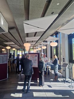 A PGR presents their research poster to a judge