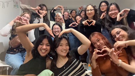 A group of friends make heart signs