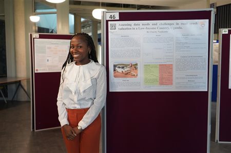 A student stands next to her presentation board