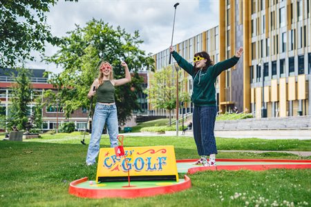 Two students celebrate as they play campus mini golf