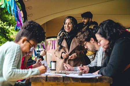 A group of students join in with a craft activity outside