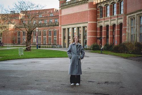 Student Content Shaper Mimi stands outside the Aston Webb building.