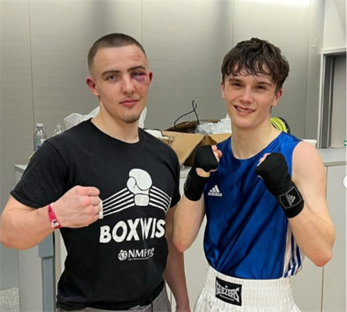 Two male students pose with a boxing stance
