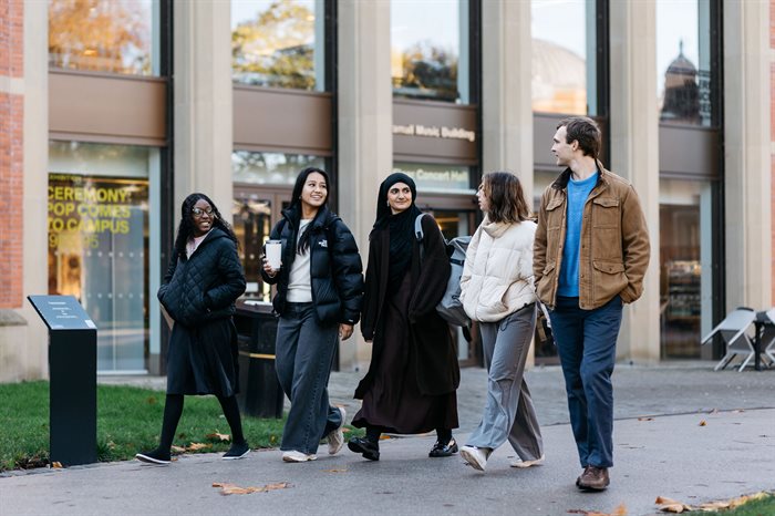 five students walk in a line outside the Bramall Music Building