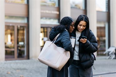 Two female students looking at a phone