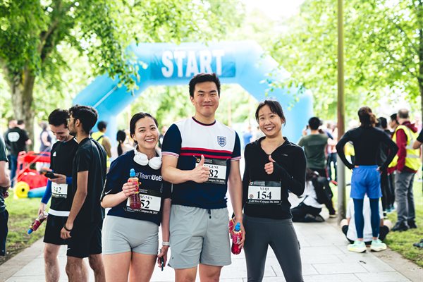 Three students with their thumbs up at the finish line